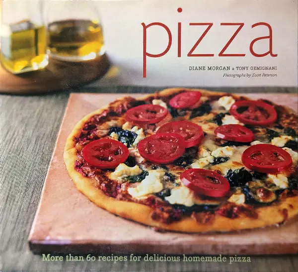 Cover of the pizza recipe book featuring a delicious homemade pizza topped with tomatoes and greens, showcasing culinary creativity.